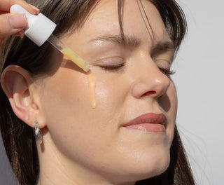 Serum wird mit einer Glaspipette auf Wange getropft