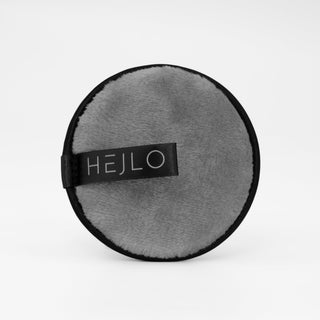 Rundes, graues Kosmetik-Pad it schwarzem Rand und HEJLO-Logo auf hellem Hintergrund